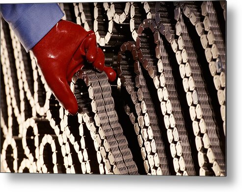 Working Metal Print featuring the photograph Red Gloved Hand Removing a Coiled Chain by Digital Vision.
