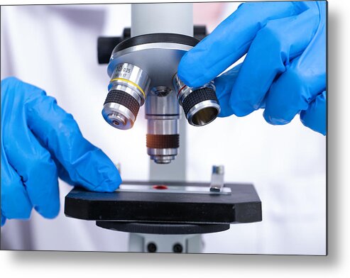 Expertise Metal Print featuring the photograph scientist looking through a microscope in a laboratory. Young scientist doing some research. by Krisanapong Detraphiphat