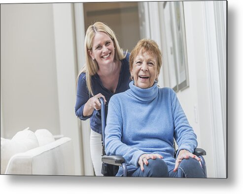 Retirement Metal Print featuring the photograph Senior woman in wheelchair with caregiver at home by Kali9