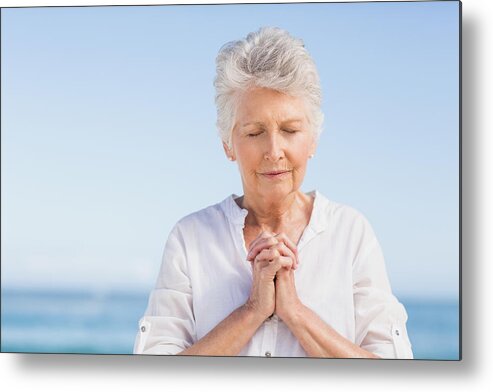 White People Metal Print featuring the photograph Senior woman praying on the beach by Wavebreakmedia