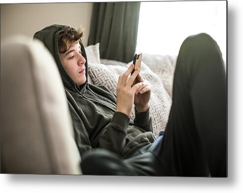 Atlanta Metal Print featuring the photograph Teenage boy using smartphone at home by MoMo Productions