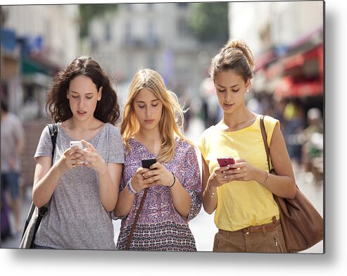 People Metal Print featuring the photograph Three girls with their mobile phone by Vincent Besnault