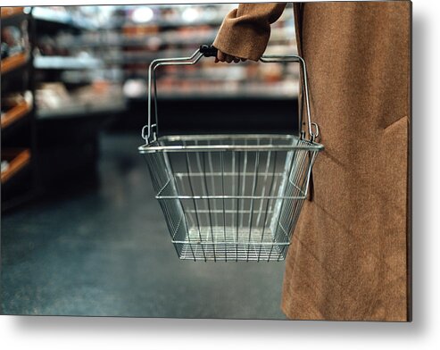 Empty Metal Print featuring the photograph Woman carrying empty shopping basket in supermarket by Oscar Wong