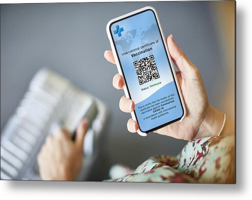 Internet Metal Print featuring the photograph Woman Checking Covid-19 Vaccine Passport On Cellphone by Morsa Images