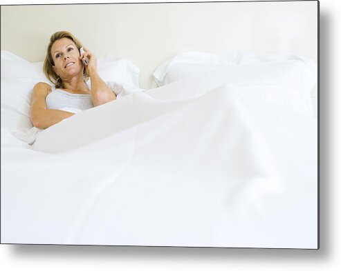 People Metal Print featuring the photograph Woman lying in bed, talking on cell phone, looking away by PhotoAlto/Frederic Cirou