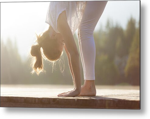 Recreational Pursuit Metal Print featuring the photograph Woman practising yoga by the lake. by VisualCommunications
