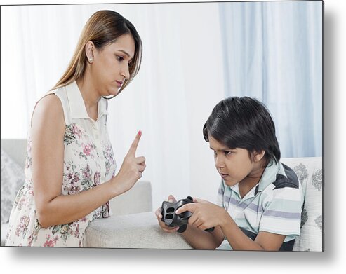 Punishment Metal Print featuring the photograph Woman scolding her son playing video game by Uniquely India