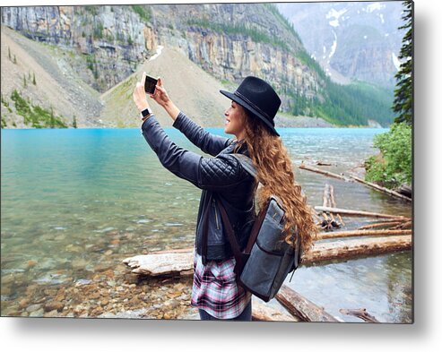 Scenics Metal Print featuring the photograph Young beautiful female backpacker doing pictures on her phone by StarZImages