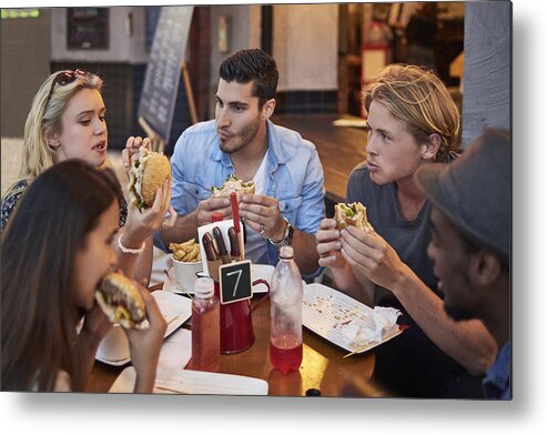 Young Men Metal Print featuring the photograph Young friends having burgers in restaurant by Xavierarnau