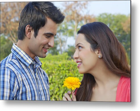 Young Men Metal Print featuring the photograph Young man giving a flower to a young woman by IndiaPix/IndiaPicture