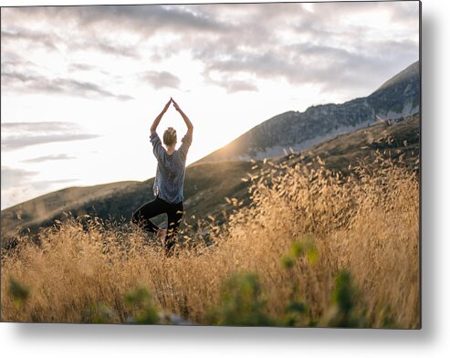 Human Arm Metal Print featuring the photograph Young woman preforms yoga in mountains in morning light by AscentXmedia