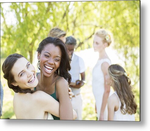 Young Men Metal Print featuring the photograph Bridesmaid and friend dancing during wedding reception in domestic garden by Caiaimage/Tom Merton