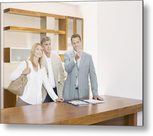 Showing Metal Print featuring the photograph Salesman with couple in interior design showroom by Robert Daly