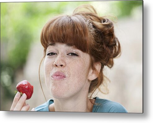 People Metal Print featuring the photograph Germany, Berlin, Close up of young woman eating strawberry, smiling, portrait by Westend61