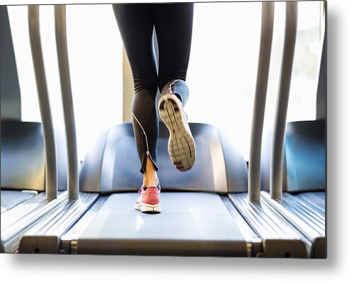 People Metal Print featuring the photograph Low section of woman exercising on treadmill by Maskot