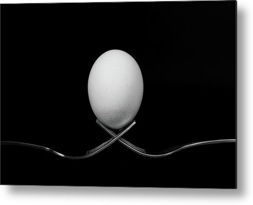 Egg Metal Print featuring the photograph White egg resting on two metal and shiny forks on a black backg by Michalakis Ppalis