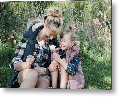 Mother Metal Print featuring the photograph Mother And Daughter Toasting Marshmallows Together Smiling Happily by Cavan Images