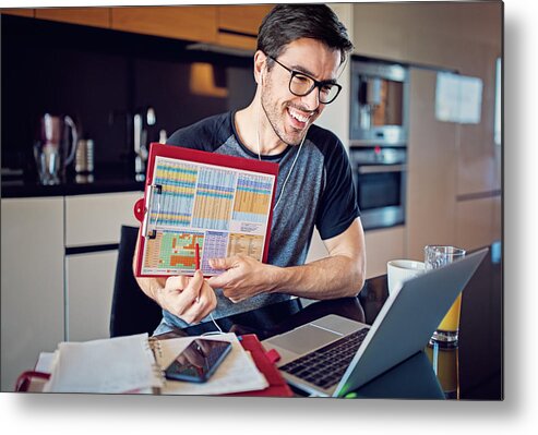 Working Metal Print featuring the photograph Man is working at home and video conferencing using his laptop by Praetorianphoto