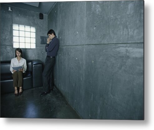 Young Men Metal Print featuring the photograph Man standing next to woman sitting on couch looking at paper. by Frederic Cirou