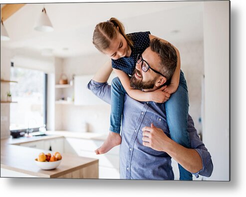 Hipster Metal Print featuring the photograph Mature father giving piggyback ride to small daughter indoors at home. by Halfpoint Images