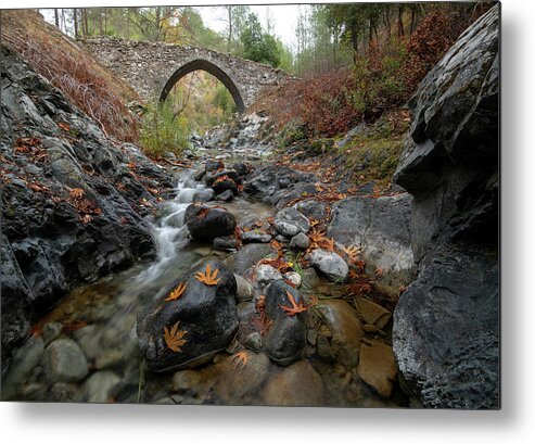 Autumn Metal Print featuring the photograph Medieval stoned bridge with water flowing in the river in autumn. by Michalakis Ppalis