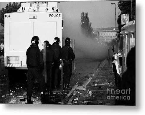 Northern Metal Print featuring the photograph PSNI riot officers behind water canon during rioting on crumlin road at ardoyne shops belfast 12th J by Joe Fox