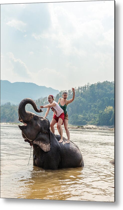 Scenics Metal Print featuring the photograph Two young women riding an elephant in the Mekong by Matteo Colombo