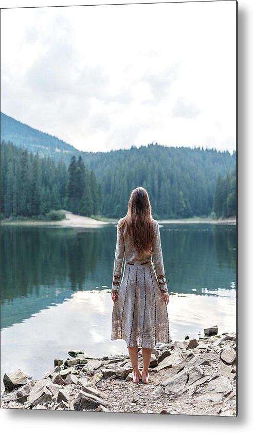 Woman Metal Print featuring the photograph Woman In A Dress Near The Lake In The Forest In The Mountains #1 by Cavan Images / Orest Filin