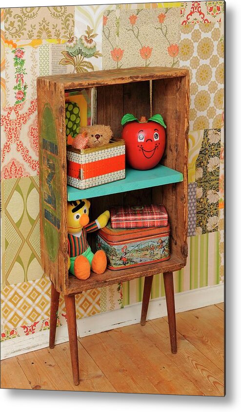 Ip_11217160 Metal Print featuring the photograph Retro-style Child's Bedroom With Diy Shelves Made From Old Wooden Crate And 50s Cabinet Legs; Old Tin, Vintage Bert And Happy Apple Toys Against Patchwork Of 70s Wallpaper by Revier 51