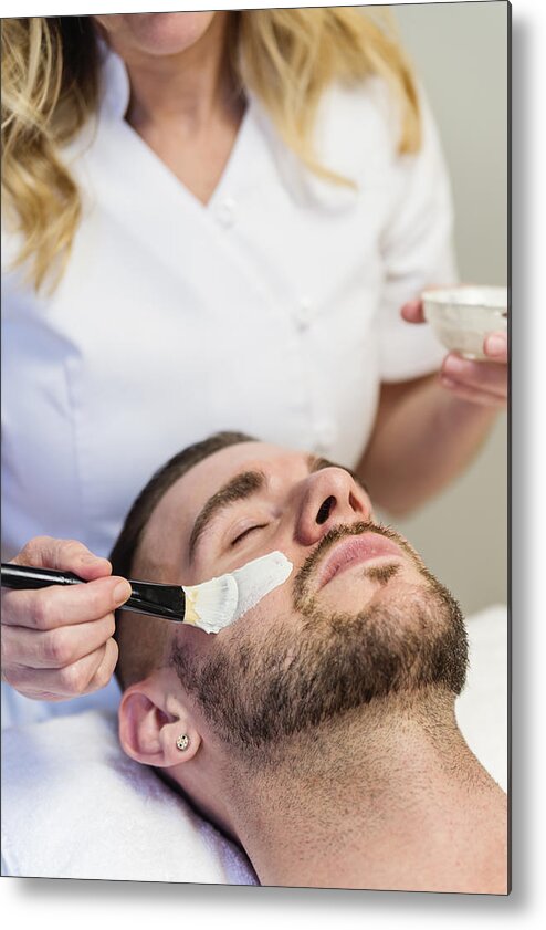 Young Men Metal Print featuring the photograph Young man receiving a facial treatment in beauty spa. #2 by Martinedoucet