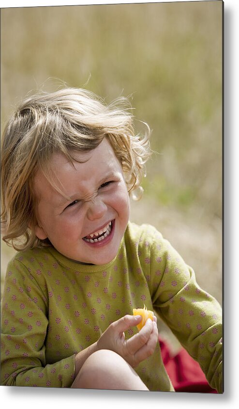 Toddler Metal Print featuring the photograph Girl eating fruit and laughing by Comstock Images