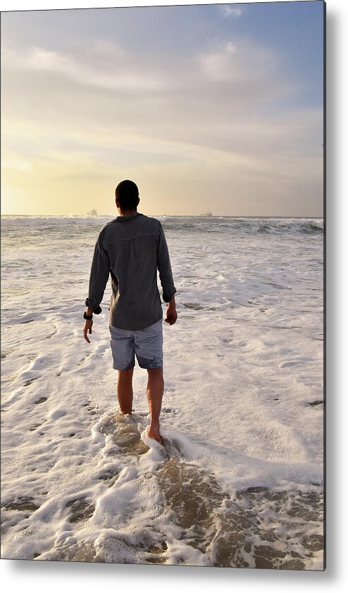 Man Metal Print featuring the photograph Man walking into the ocean at sunset stock photo by Mark Stout