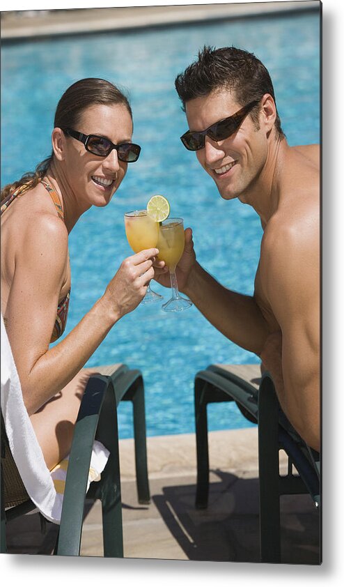 Mid Adult Women Metal Print featuring the photograph Poolside couple with cocktails by Comstock Images