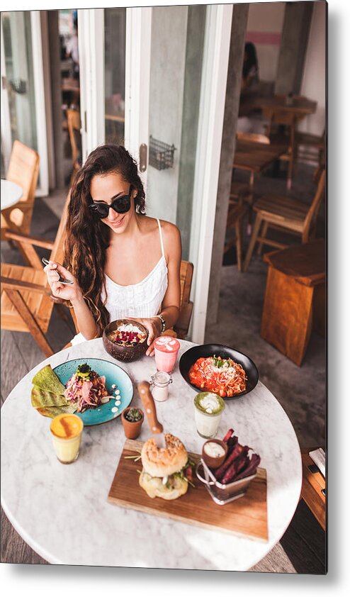 Breakfast Metal Print featuring the photograph Young smiling woman having breakfast in stylish street cafe. Smoothie bowl, matcha latte, tacos and burger by Olegbreslavtsev