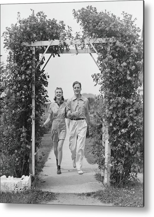Young Men Metal Print featuring the photograph Couple Walking On Footpath Towards Rose by George Marks