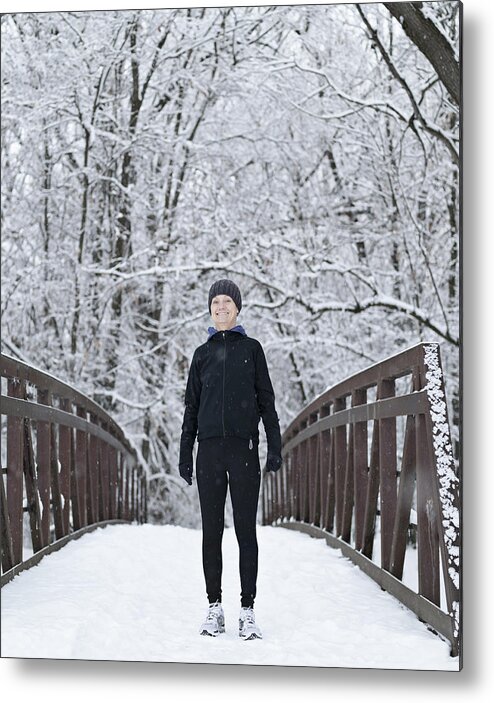 Mature Adult Metal Print featuring the photograph Woman dressed for winter running on snowy bridge by Tony Anderson