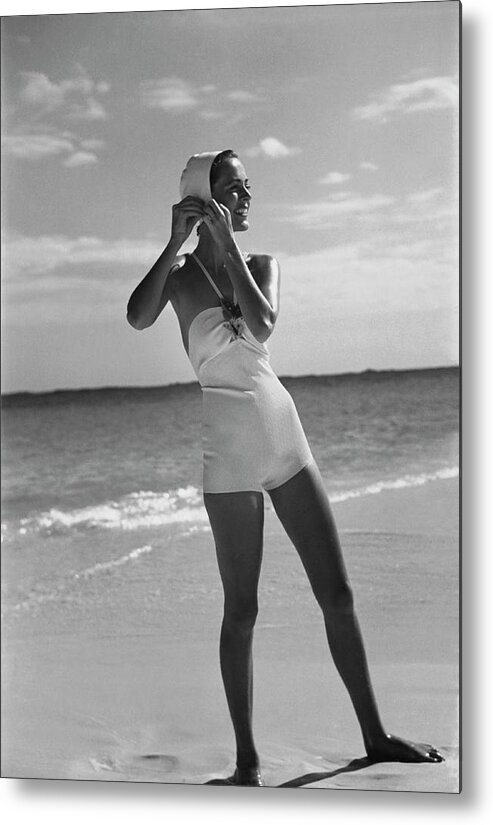 Accessories Metal Print featuring the photograph Model on a Beach Fastening Her Bathing Cap by Toni Frissell