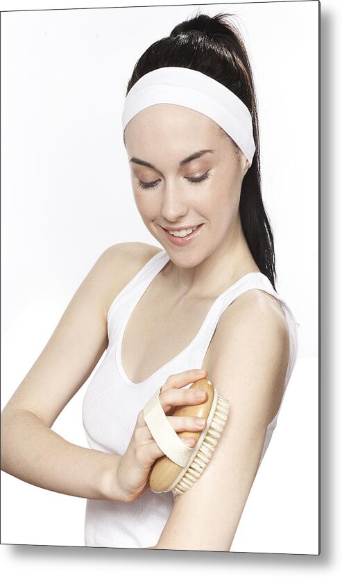 Headband Metal Print featuring the photograph Young woman scrubbing her skin with a soft brush by Paper Boat Creative