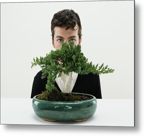 White Background Metal Print featuring the photograph Young man behind bonsai tree, portrait by Digital Vision