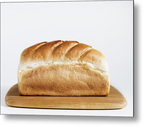 White Background Metal Print featuring the photograph Loaf of bread on chopping board, close-up by Diamond Sky Images