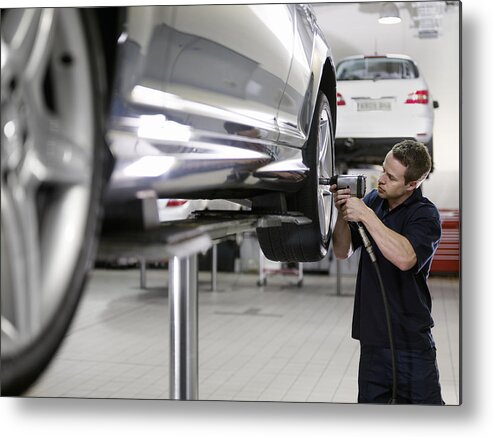 Expertise Metal Print featuring the photograph Mechanic working on car in auto repair shop by Adam Gault