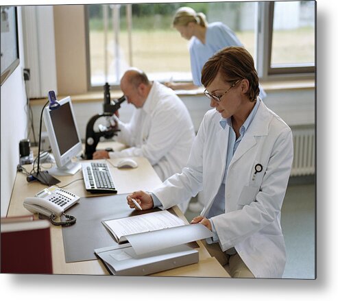 Expertise Metal Print featuring the photograph Female doctor sitting in office, portrait by Jochen Sands