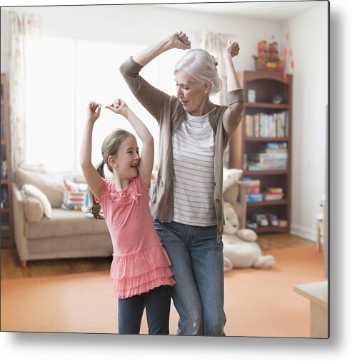 Human Arm Metal Print featuring the photograph Caucasian grandmother and granddaughter dancing in living room by Jose Luis Pelaez Inc