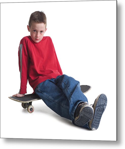Child Metal Print featuring the photograph A Caucasian Boy In Jeans And A Red Sweater Sits On His Skateboard And Smiles Slightly by Photodisc