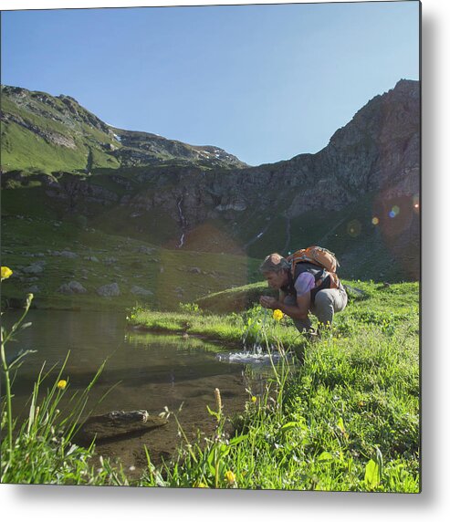 Scenics Metal Print featuring the photograph Hiker Scooping Water To Drink From by Ascent/pks Media Inc.