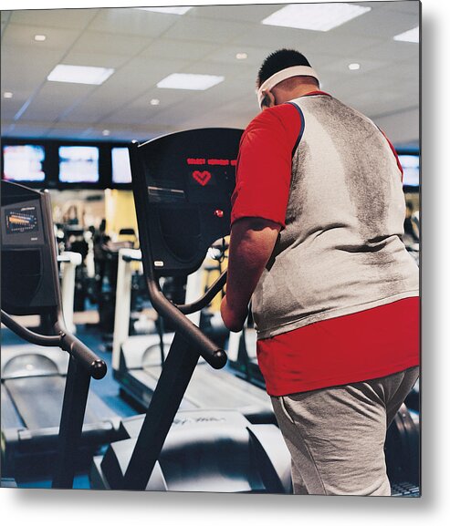 Three Quarter Length Metal Print featuring the photograph Rear View of a Man Walking on a Running Machine by Digital Vision.