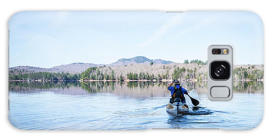 Canoeing Galaxy Case featuring the photograph Man Paddling Canoe On Calm Water Under Blue Sky by Cavan Images