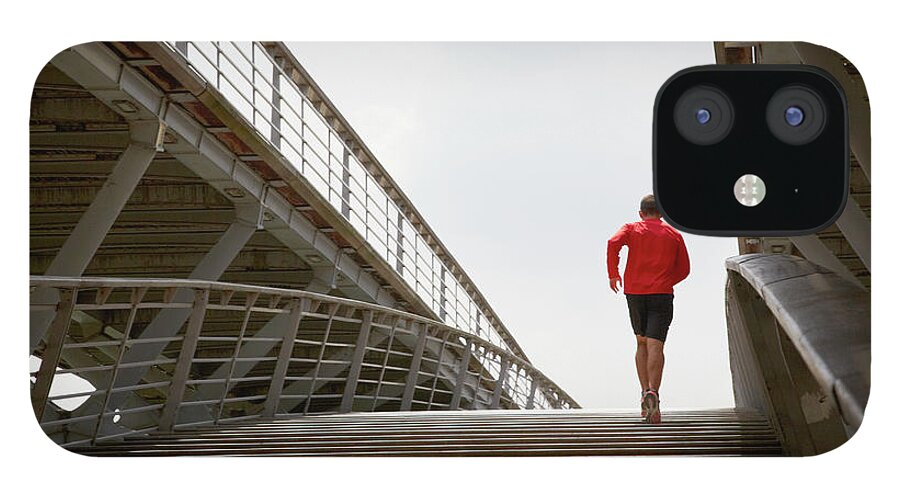 Steps iPhone 12 Case featuring the photograph Man Running Up A Bridge by Chris Tobin