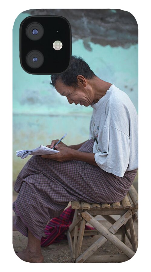 People iPhone 12 Case featuring the photograph Man Writing In Notepad, Bagan, Myanmar by Cultura Rm Exclusive/yellowdog