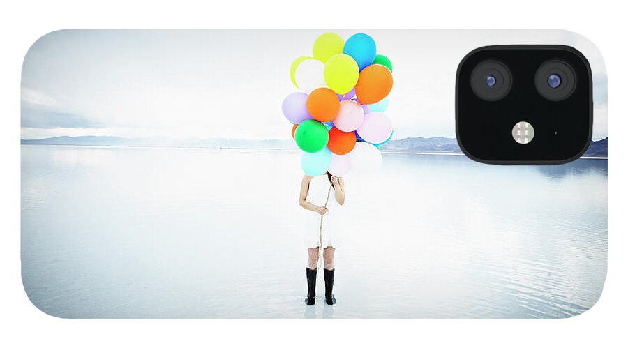 Scenics iPhone 12 Case featuring the photograph Woman In Water Standing Behind Balloons by Thomas Barwick
